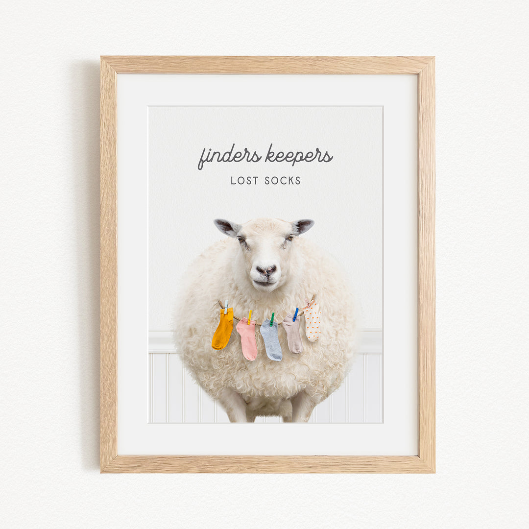 A framed image of a sheep with a sign above it that reads "finders keepers lost socks".