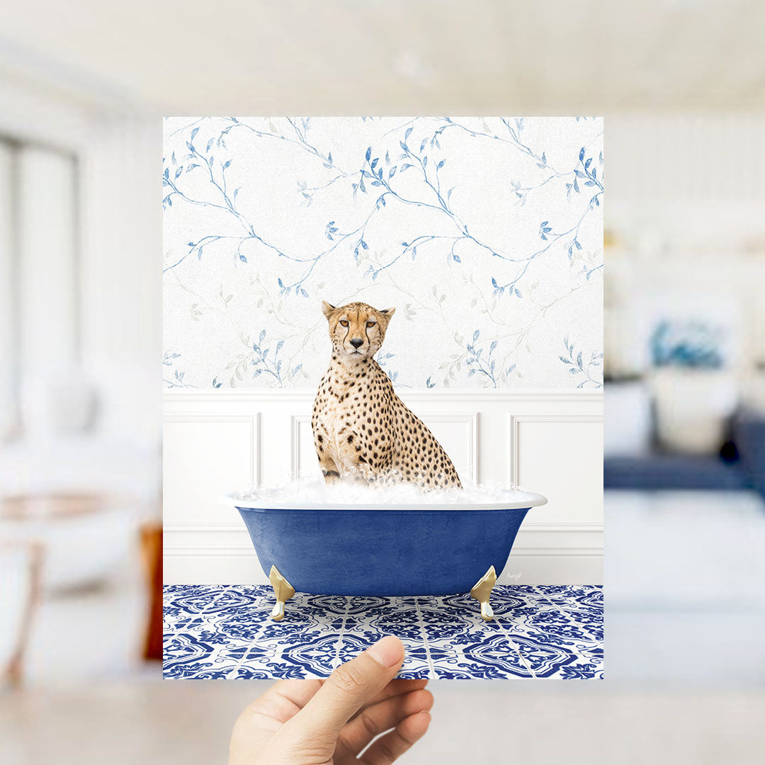 A cheetah sitting in a blue bathtub filled with water, with a patterned tile floor and a floral wallpaper in the background.