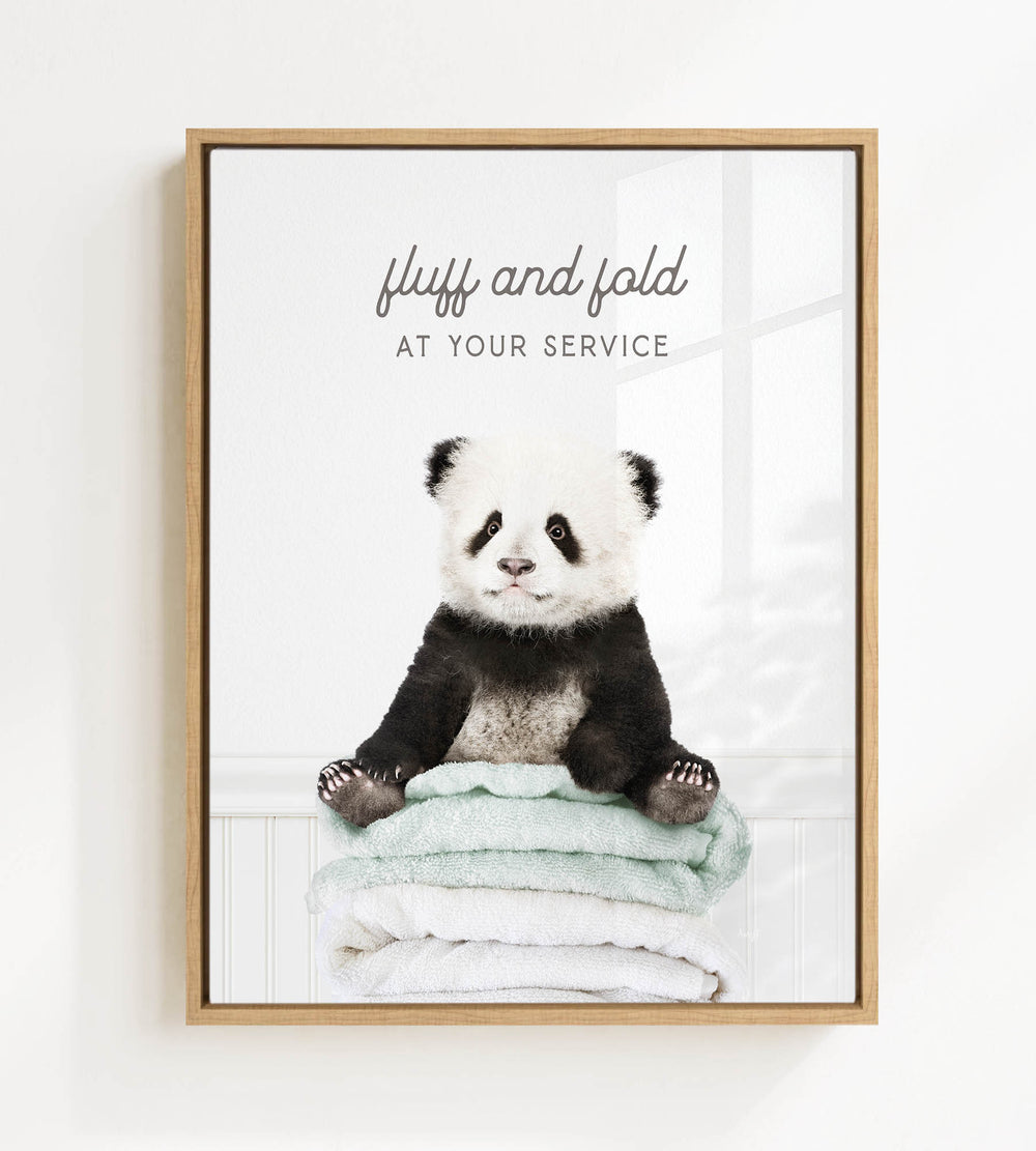 A panda bear sitting on a stack of towels, with the text "fluff and fold at your service" written above the image.