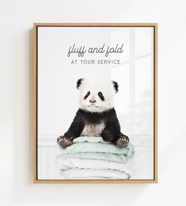A panda bear sitting on a stack of towels, with the text "fluff and fold at your service" written above the image.