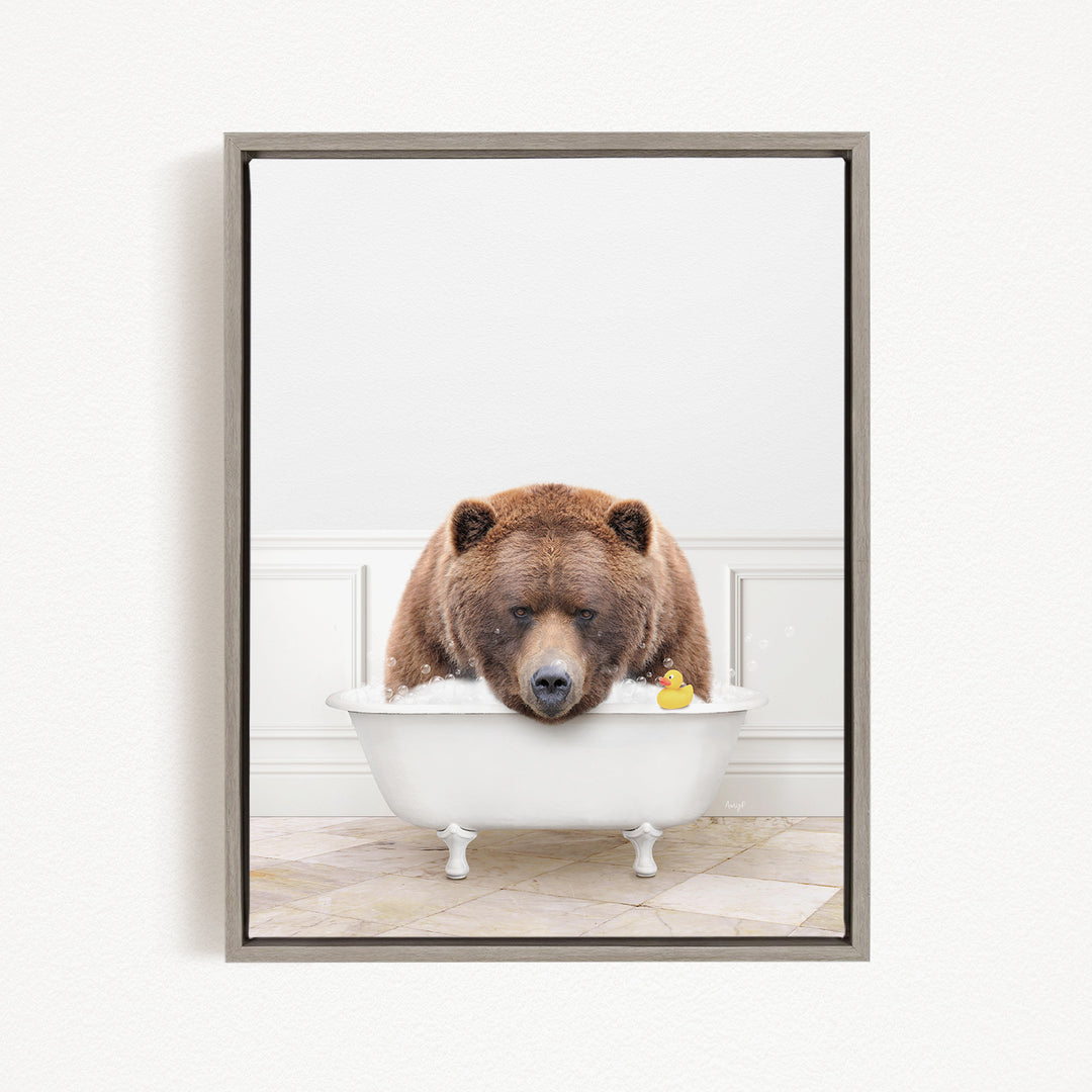 A brown bear is sitting in a white bathtub, with a rubber duck floating in the water.