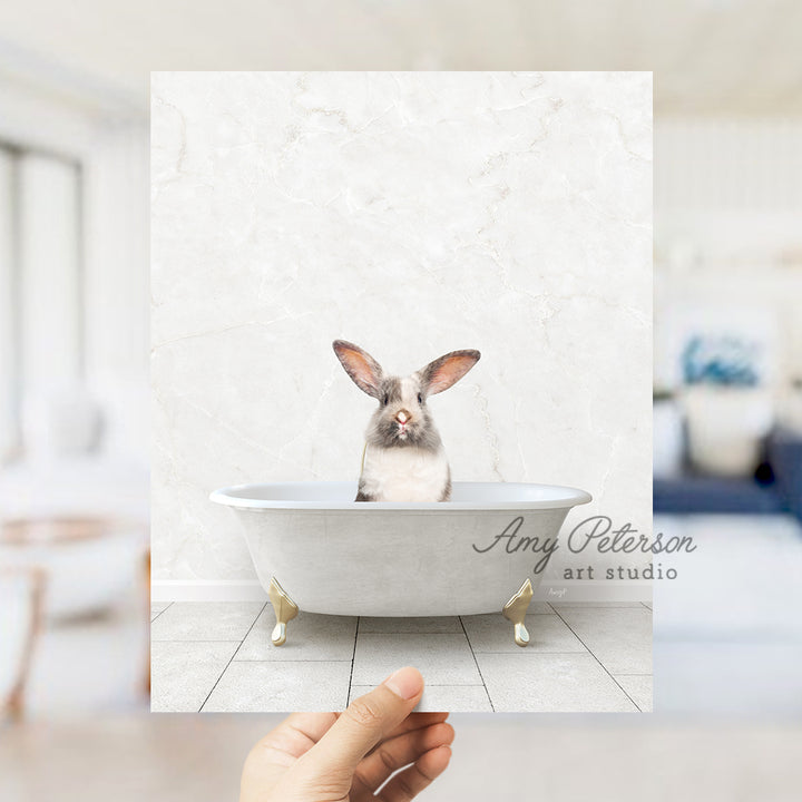 a person holding up a photo of a rabbit in a bathtub