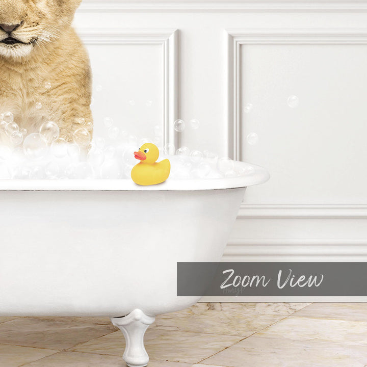 A yellow rubber duck sits in a white bathtub filled with bubbles, with a cat standing on the edge of the tub.