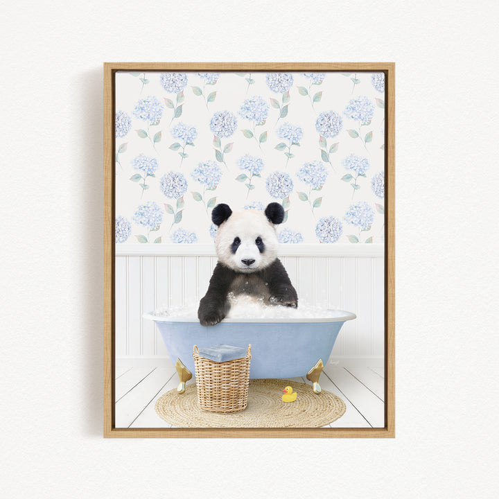 A panda bear sitting in a blue bathtub, surrounded by a wicker basket and rubber duckies, with a floral patterned wall behind it.