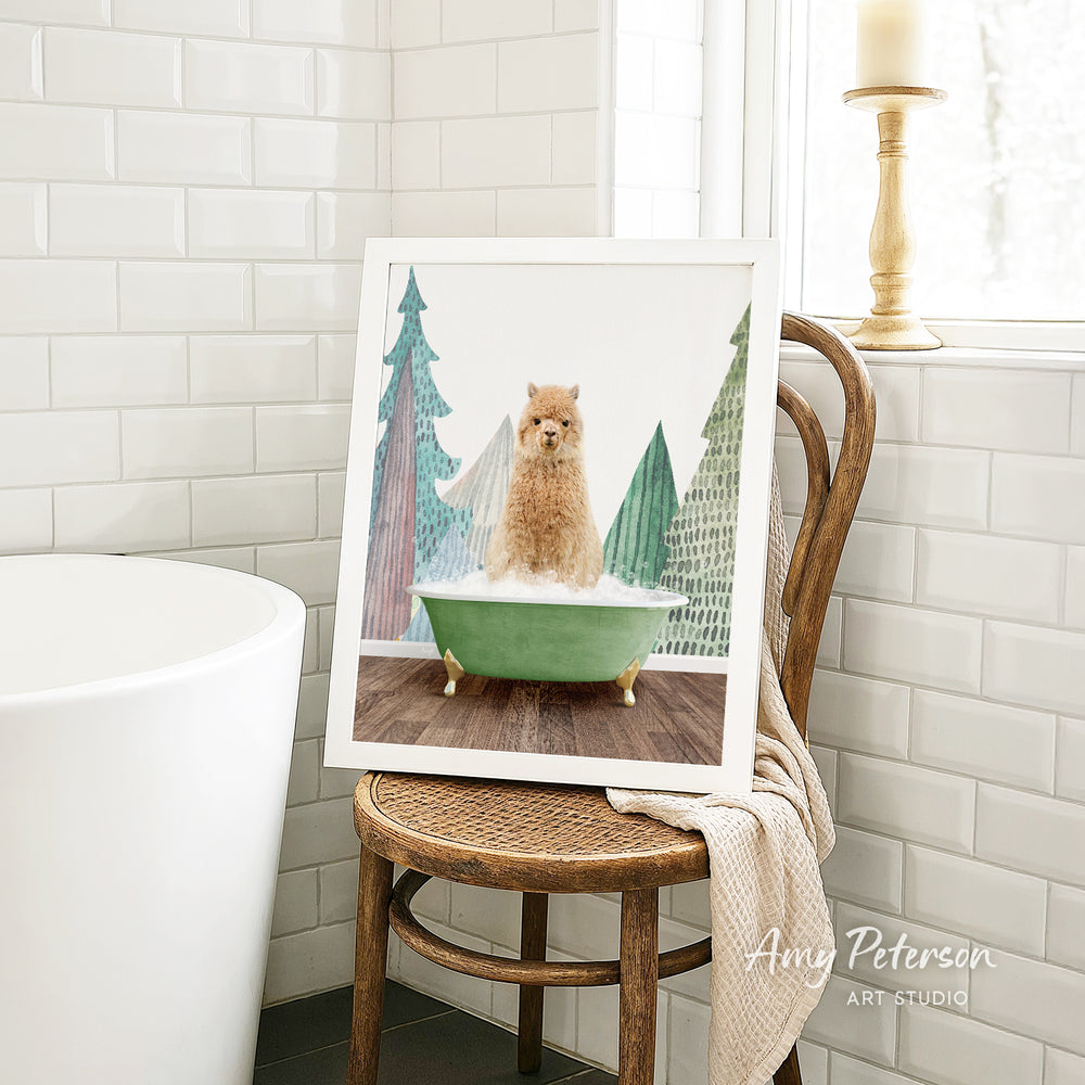 A framed image of a small dog sitting in a green bathtub, surrounded by Christmas trees, is displayed on a wooden chair in a bathroom setting.