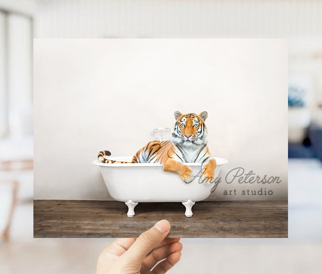 a hand holding up a picture of a tiger in a bathtub