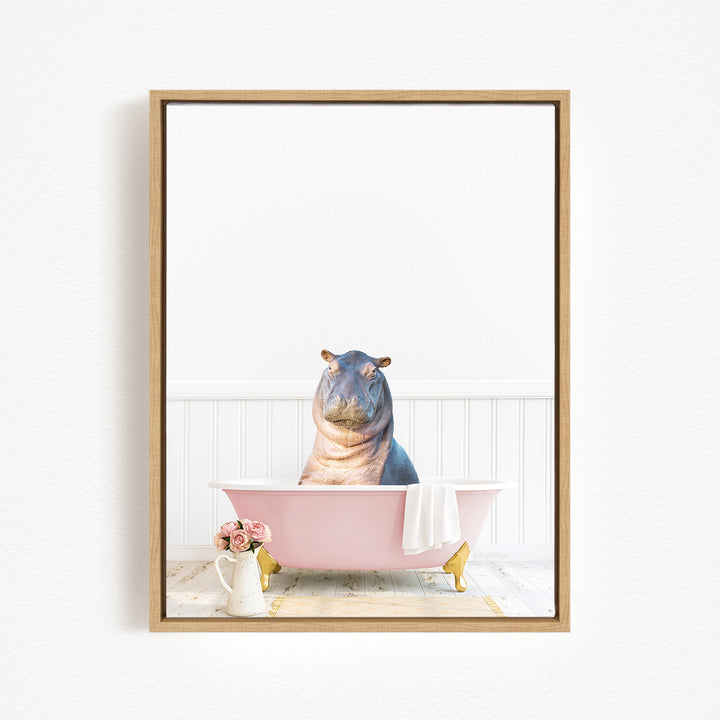 A framed image depicting a hippopotamus sitting in a pink bathtub, surrounded by flowers and a white vase.