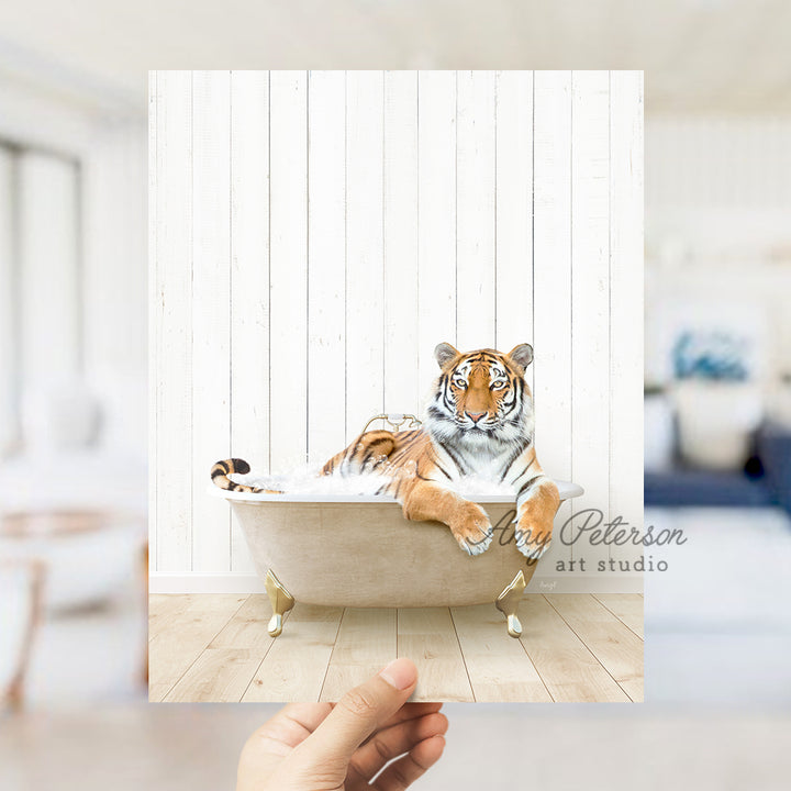 a hand holding up a picture of a tiger in a bathtub