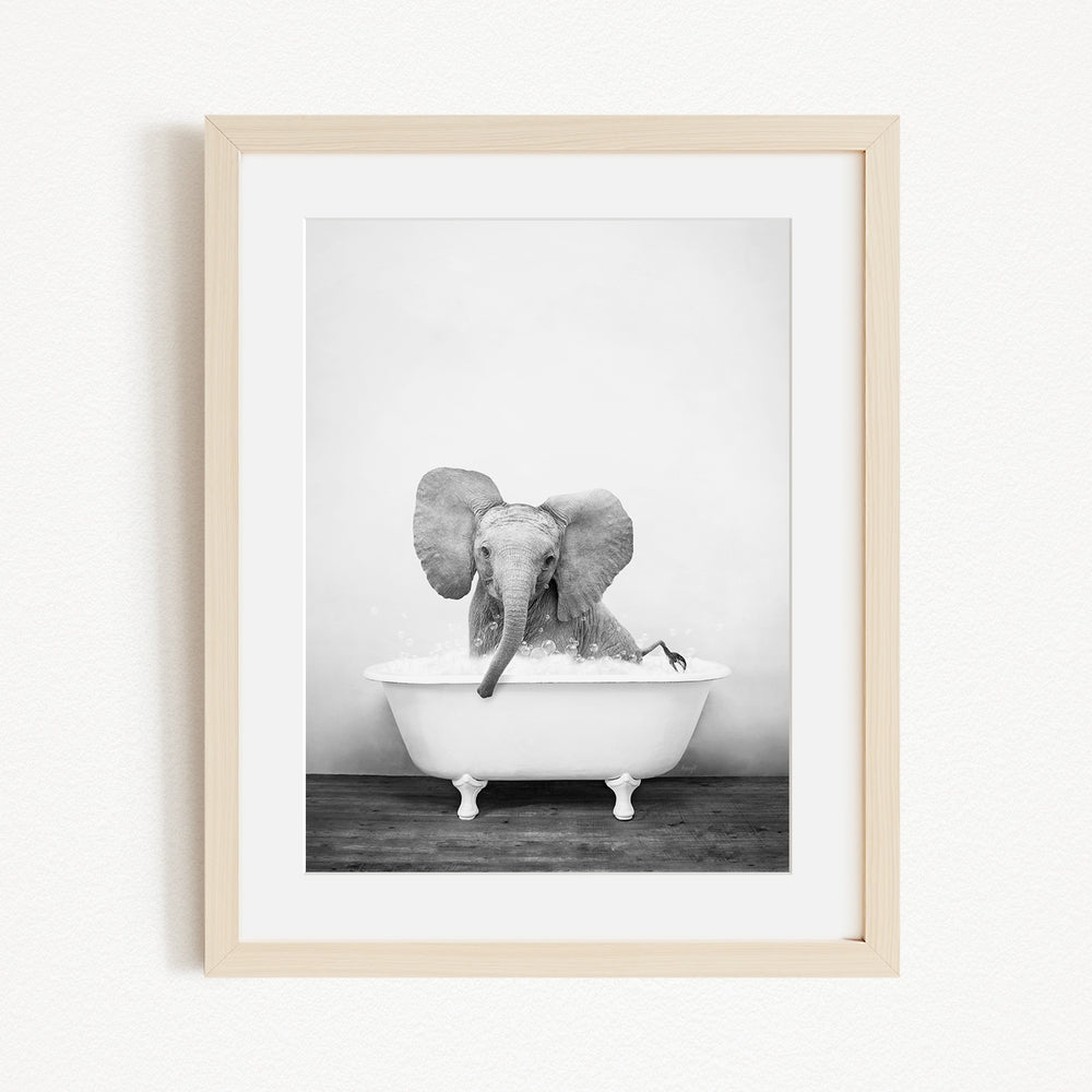 A baby elephant sitting in a bathtub, enjoying a bath.