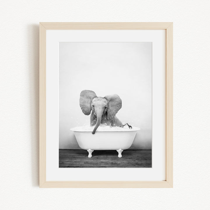A baby elephant sitting in a bathtub, enjoying a bath.