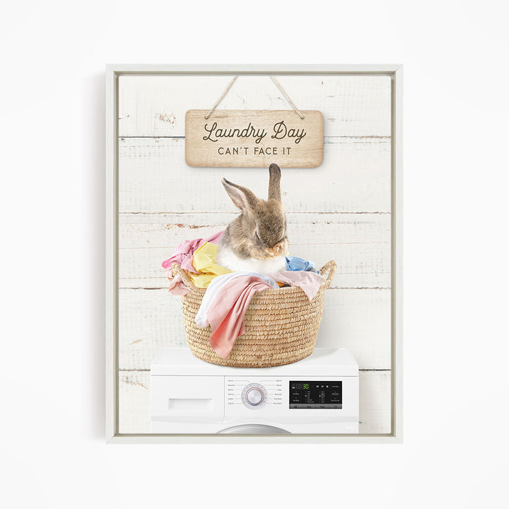 A cute rabbit sitting in a woven laundry basket, with a sign above that says "Laundry Day Can't Face It".