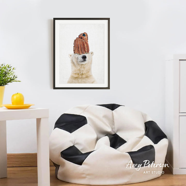 a polar bear wearing a baseball cap, which is hanging on a wall in a room with a white table and a black and white bean bag chair.