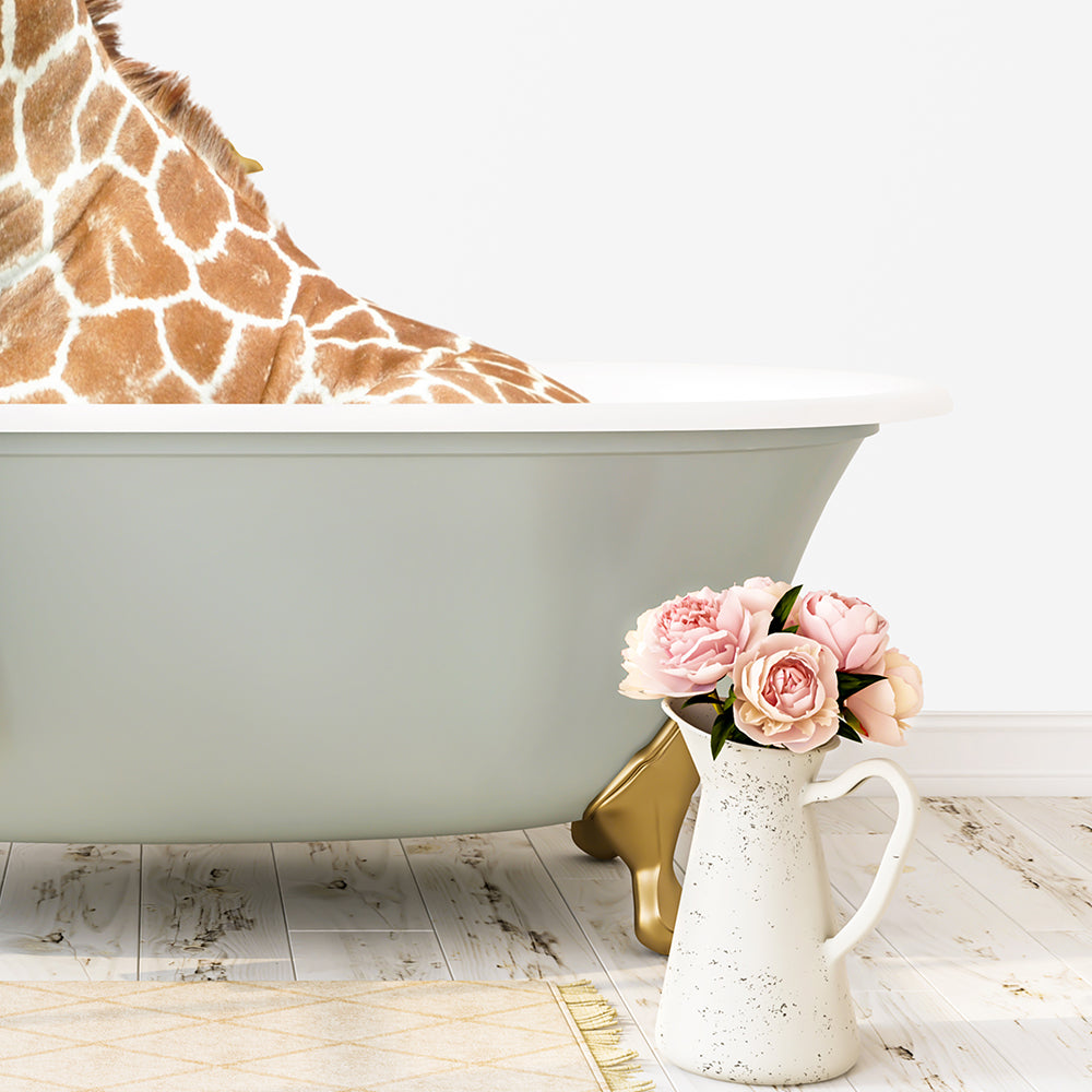 A giraffe is sitting in a bathtub filled with water, surrounded by pink flowers and a white vase on a wooden floor.