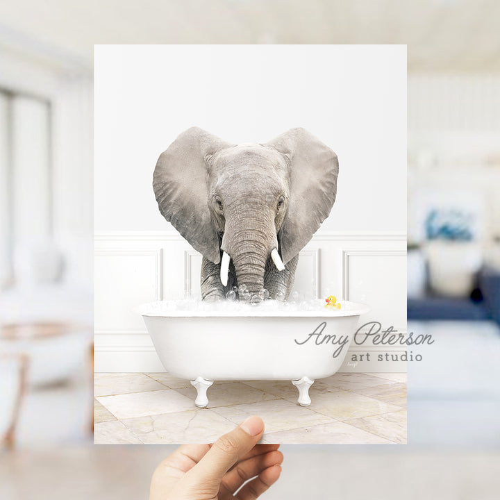 a person holding up a card with an elephant in a bathtub