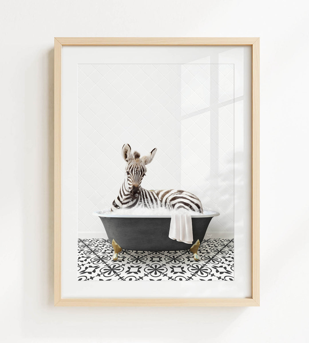 A zebra is sitting in a black bathtub, surrounded by a black and white patterned floor.
