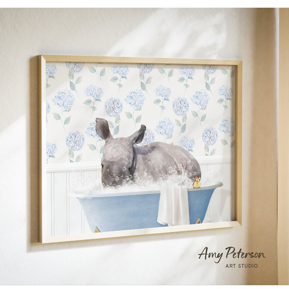 A rhinoceros is sitting in a blue bathtub filled with bubbles, surrounded by a floral pattern on the wall behind it.