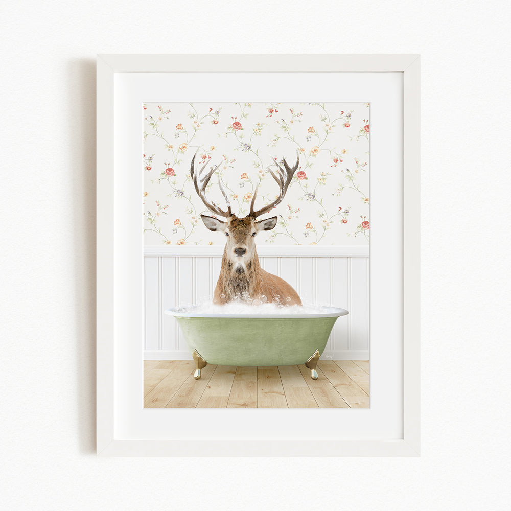 A deer with antlers is sitting in a green bathtub, surrounded by a floral wallpaper.
