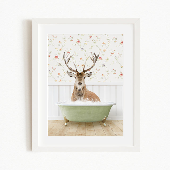 A deer with antlers is sitting in a green bathtub, surrounded by a floral wallpaper.