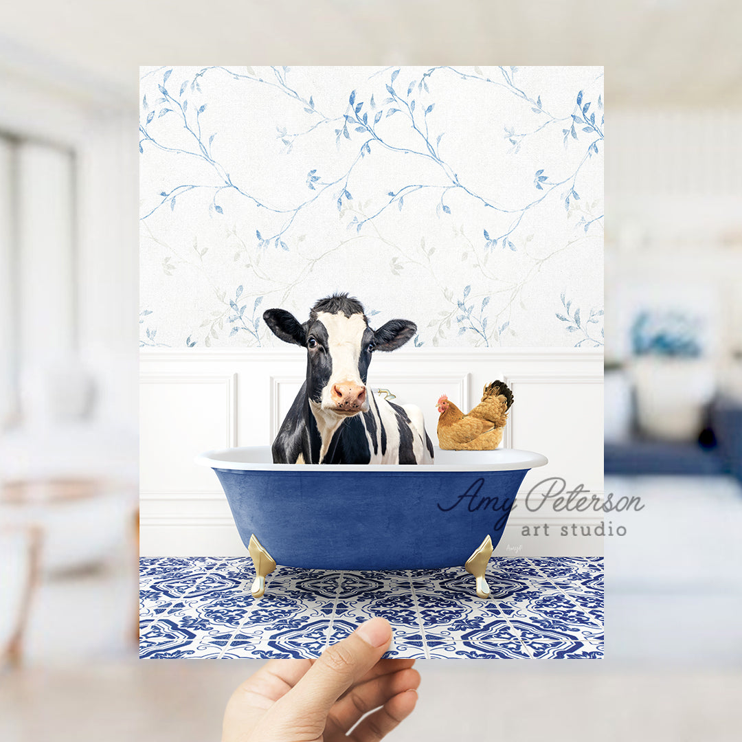 a hand holding up a card with a picture of a cow in a bathtub