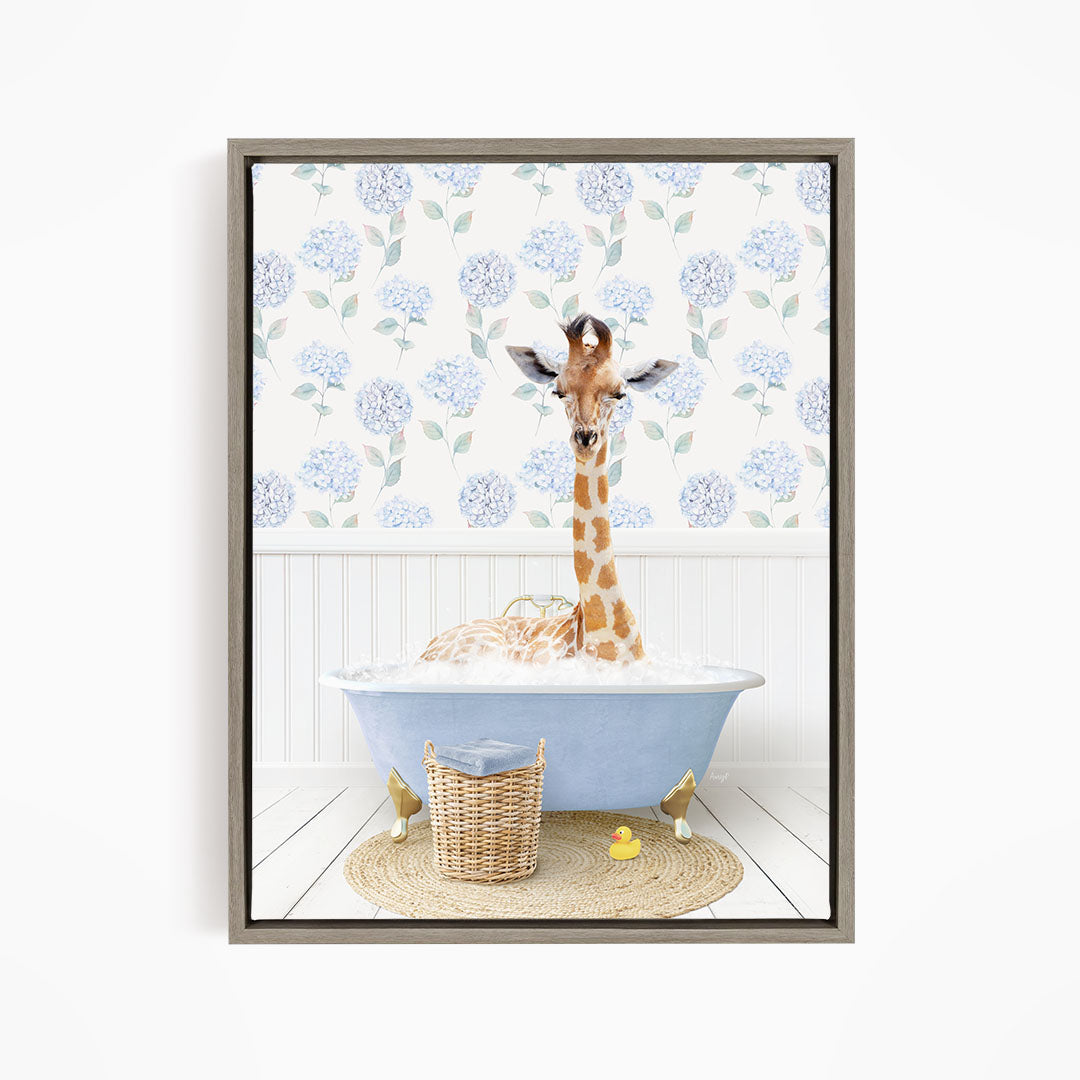 A giraffe is sitting in a blue bathtub filled with water, surrounded by a wicker basket and rubber ducks.