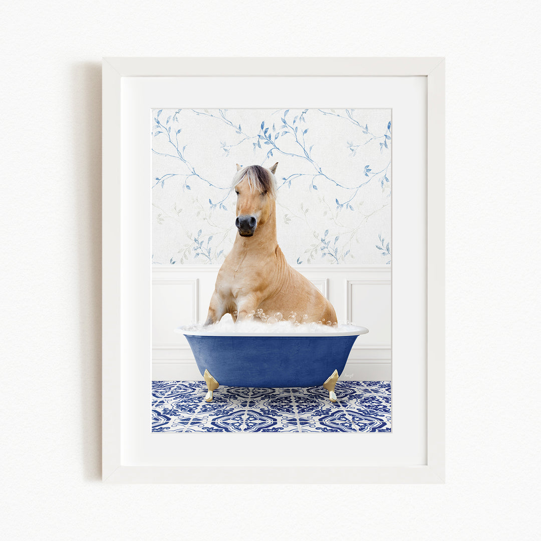 A light brown horse is sitting in a blue bathtub filled with water, surrounded by a blue and white patterned floor.