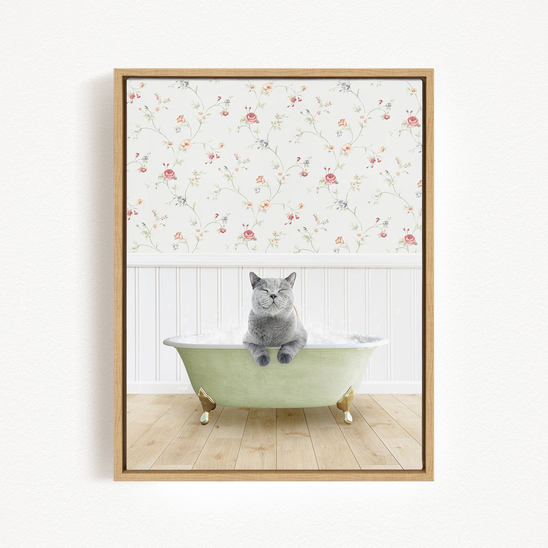 A gray cat sitting in a green bathtub, with a floral wallpaper in the background.