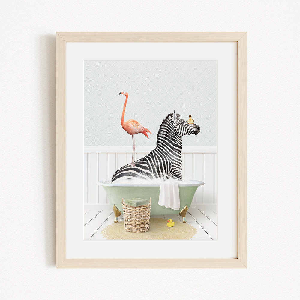 A framed image depicting a zebra sitting in a bathtub, with a flamingo standing on its back and a basket of rubber ducks nearby.