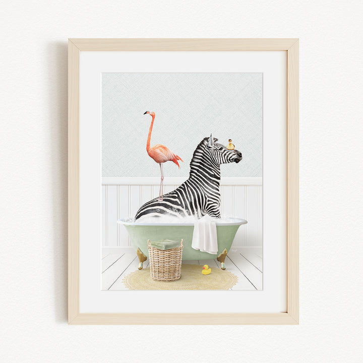 A framed image depicting a zebra sitting in a bathtub, with a flamingo standing on its back and a basket of rubber ducks nearby.