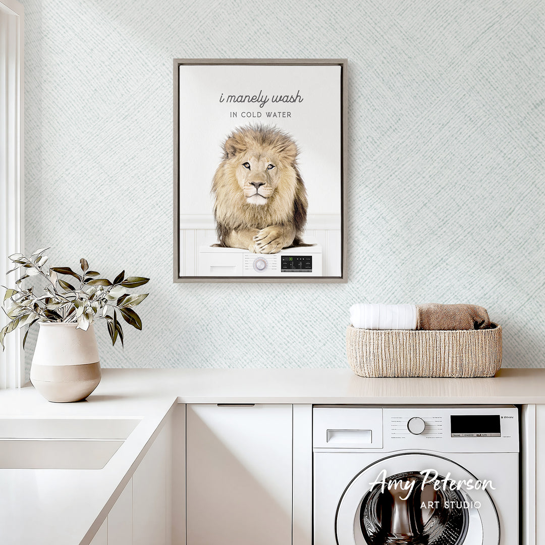 a framed poster of a lion on a wall above a laundry basket, with a potted plant and a washing machine visible in the foreground.