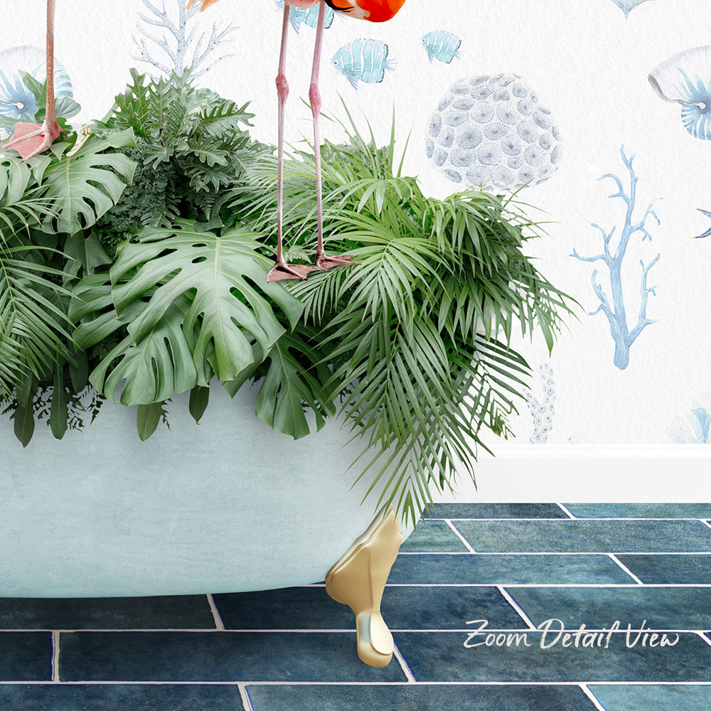 A large green plant with long leaves is placed in a white bathtub, with a pair of flamingos standing on the tub's edge. The background features a blue and white patterned wall.