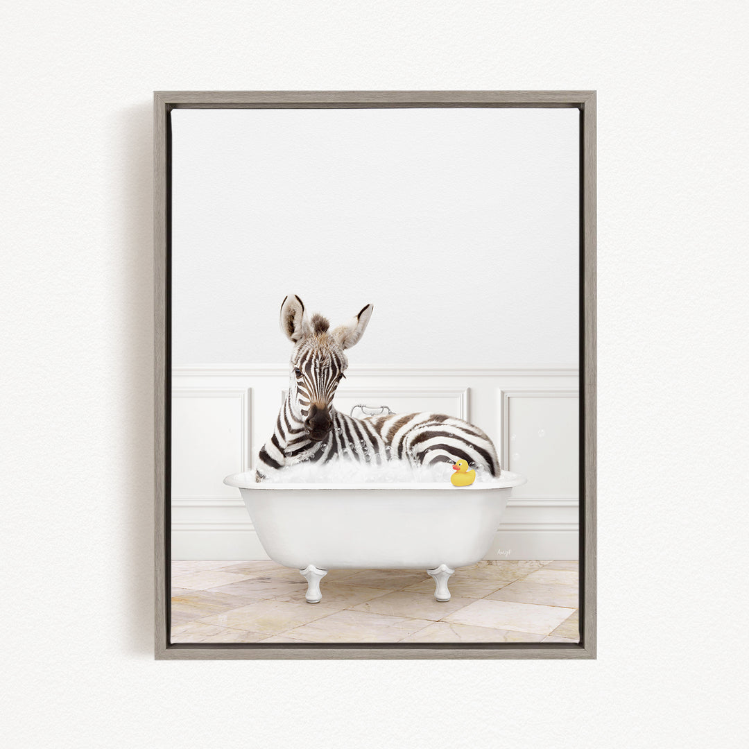 A zebra is sitting in a white bathtub filled with bubbles, with a rubber duck floating nearby.