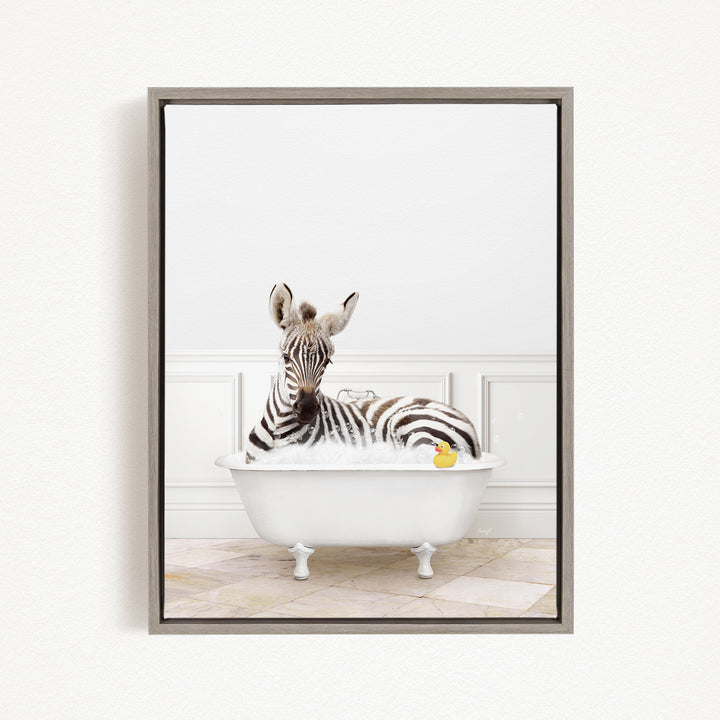 A zebra is sitting in a white bathtub filled with bubbles, with a rubber duck floating nearby.