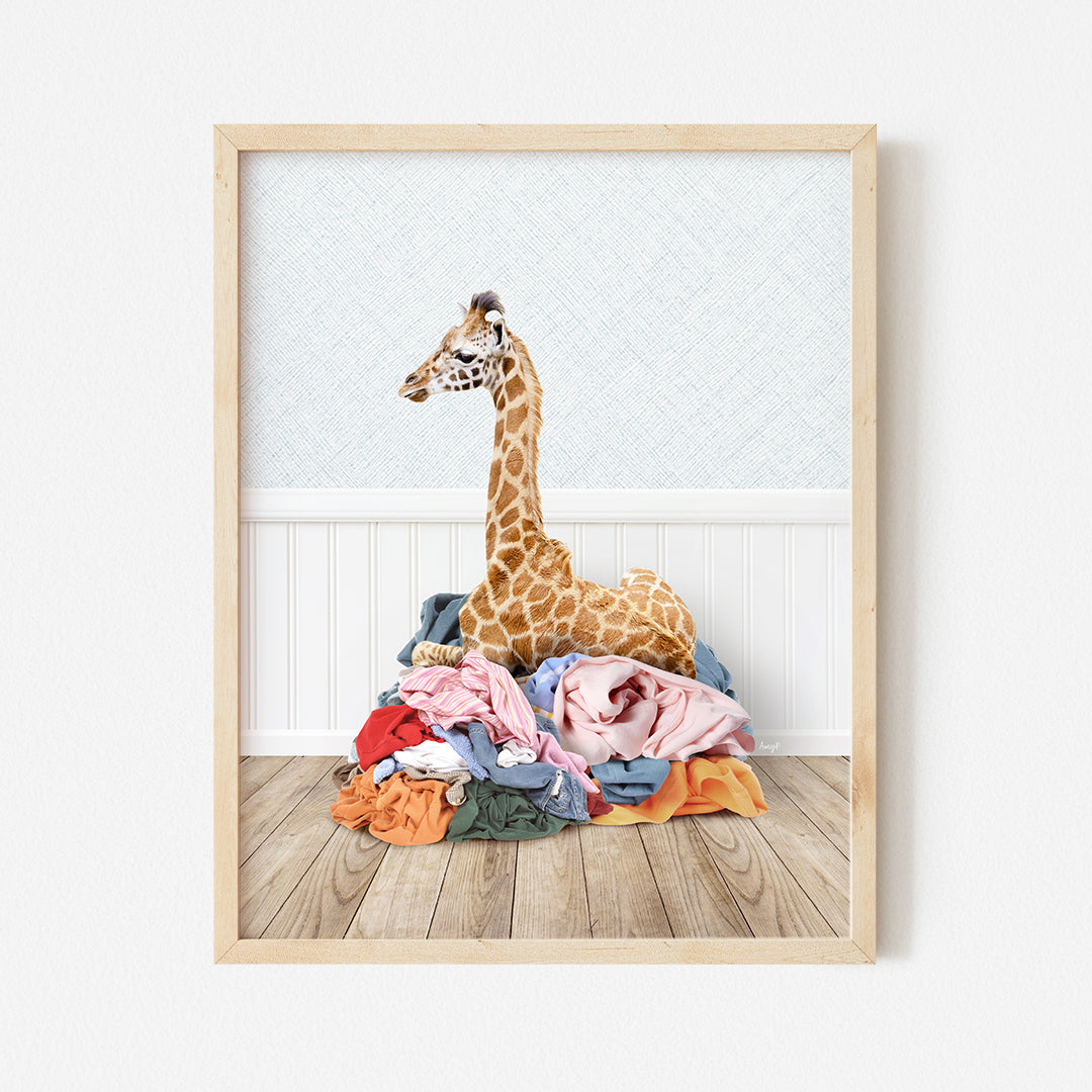 a giraffe sitting on top of a pile of clothes