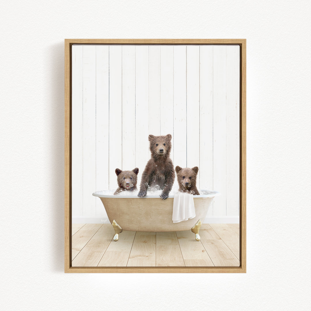 A framed image depicting three adorable brown bears sitting in a bathtub, with one bear standing and the other two sitting.