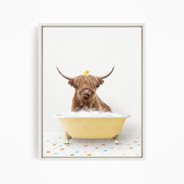 A Highland cow with long horns is sitting in a yellow bathtub filled with bubbles, with a rubber duck perched on its head.