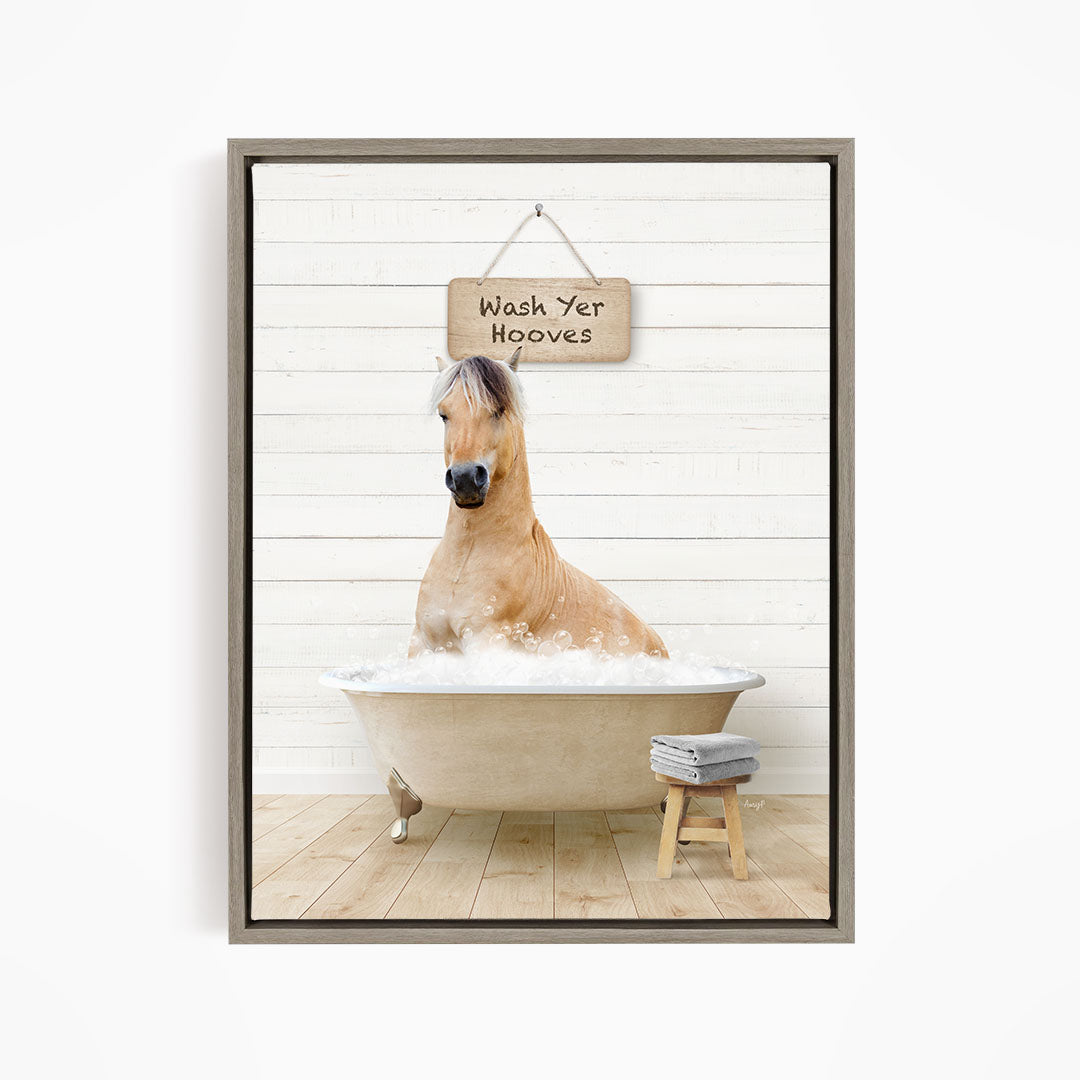 A light brown horse is sitting in a bathtub filled with water, with a sign above it that says "Wash Yer Hooves".