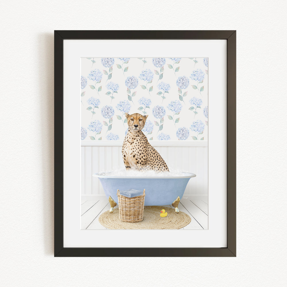 A cheetah sitting in a blue bathtub filled with water, surrounded by a floral patterned wall and a basket of rubber ducks.