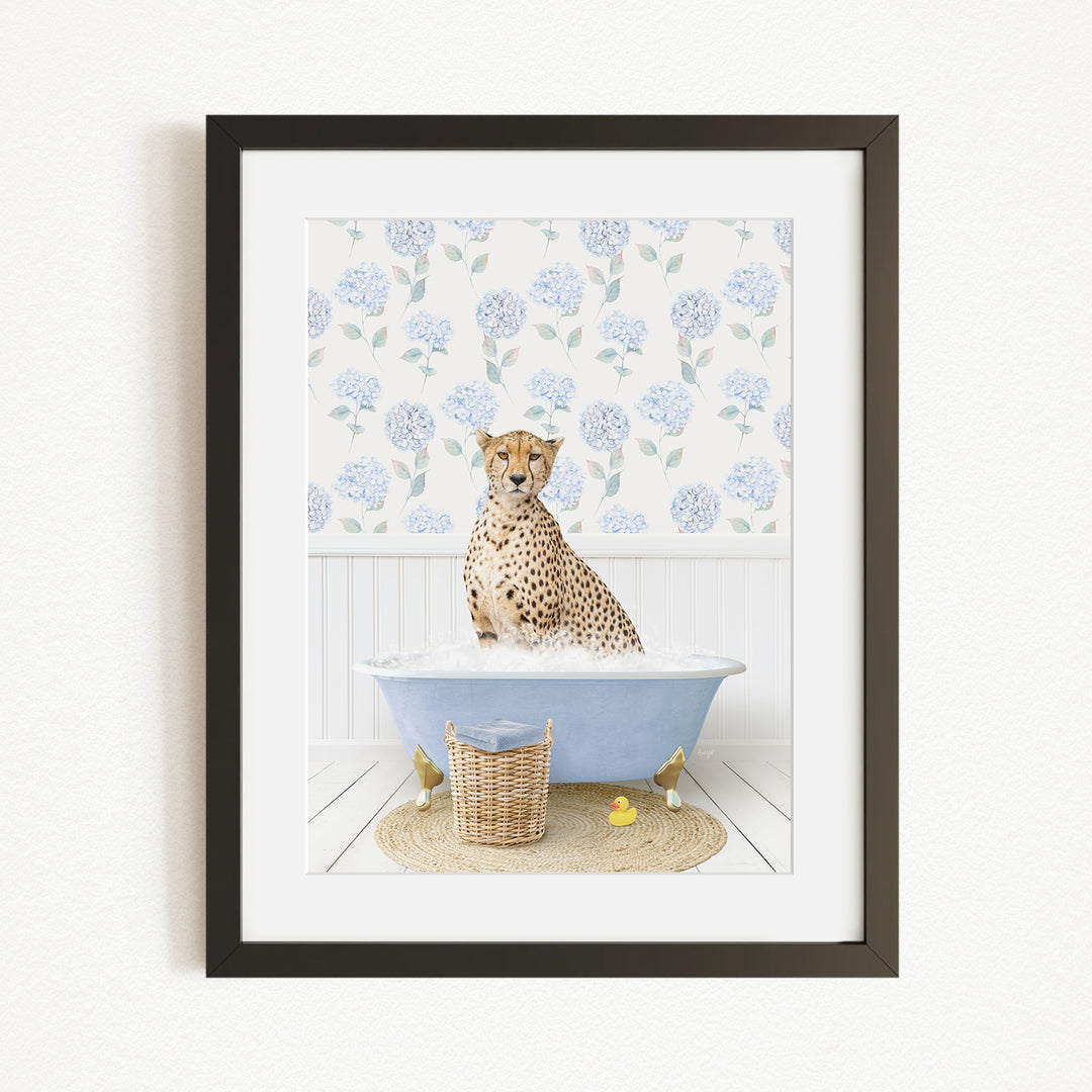 A cheetah sitting in a blue bathtub filled with water, surrounded by a floral patterned wall and a basket of rubber ducks.