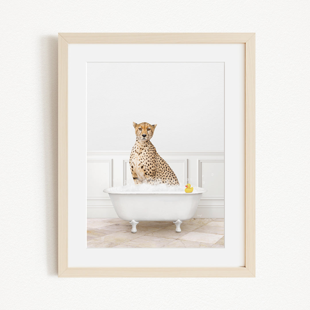 A cheetah sitting in a white bathtub filled with water, with a yellow rubber duck floating in the water.