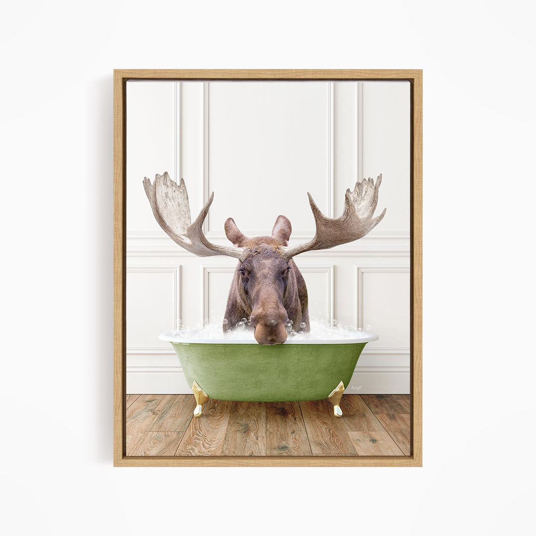A moose with large antlers is sitting in a green bathtub filled with water, creating a whimsical and humorous scene.