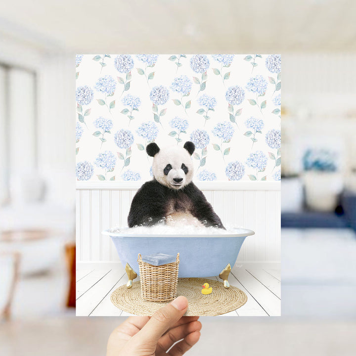 A panda bear sitting in a blue bathtub filled with bubbles, surrounded by a floral patterned wall.