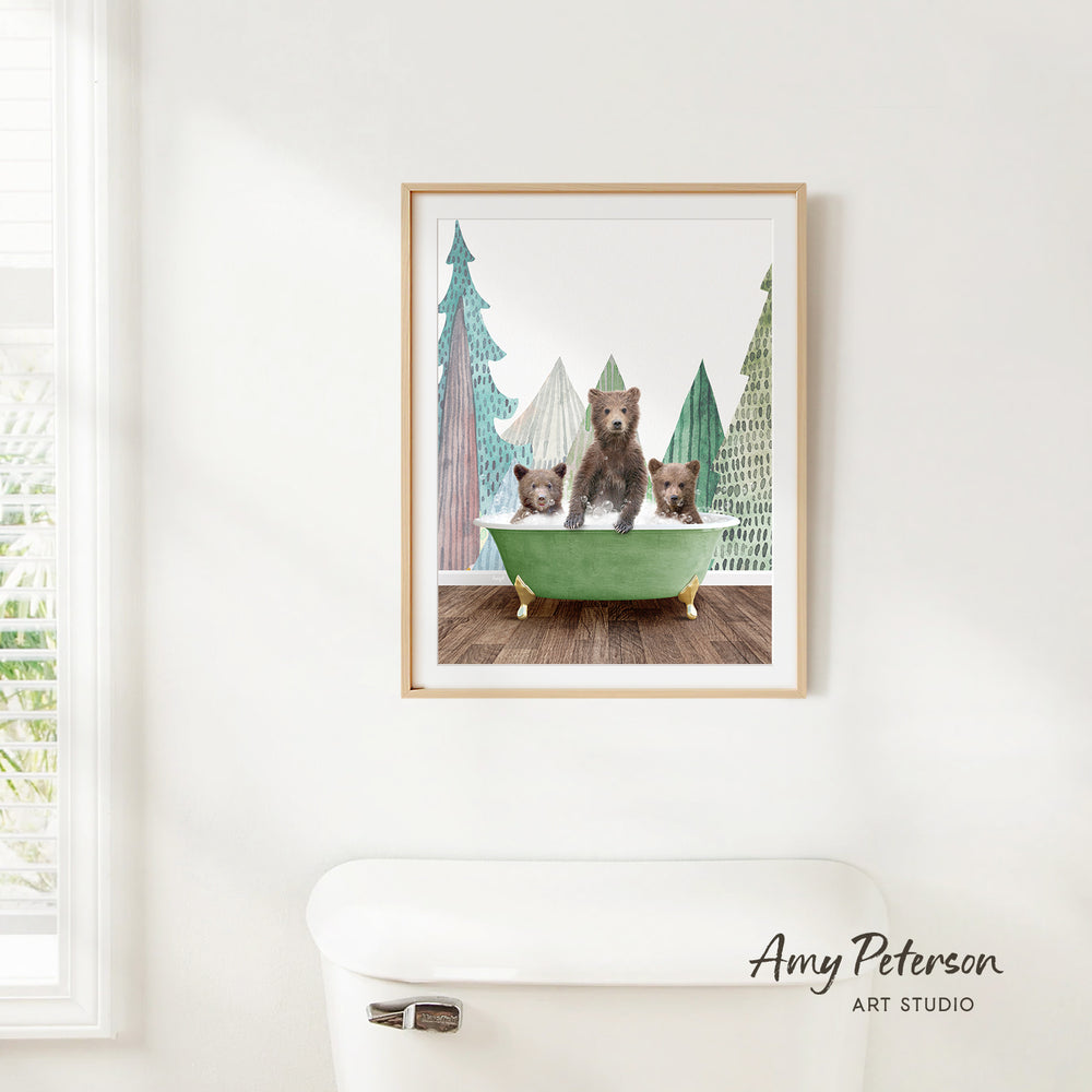 A framed print of three bears sitting in a bathtub, surrounded by trees, is hanging on a white wall.