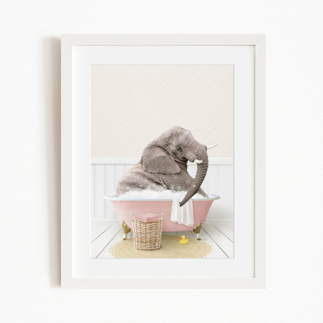 A gray elephant is sitting in a pink bathtub filled with bubbles, surrounded by a yellow rubber duck and a basket.