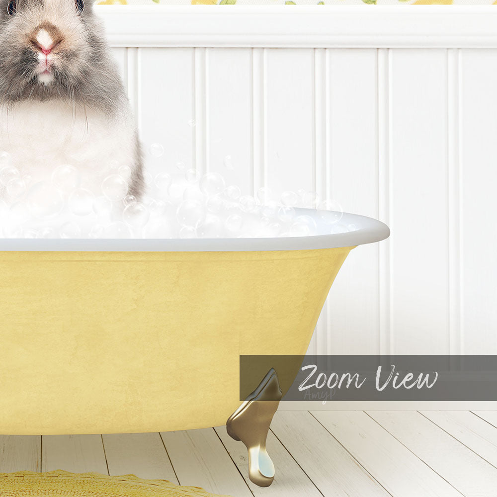 A fluffy gray and white rabbit sitting in a yellow bathtub filled with bubbles, with a white wall and wooden floor in the background.