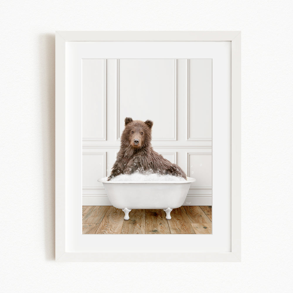 A brown bear sitting in a white bathtub filled with water, looking directly at the camera.