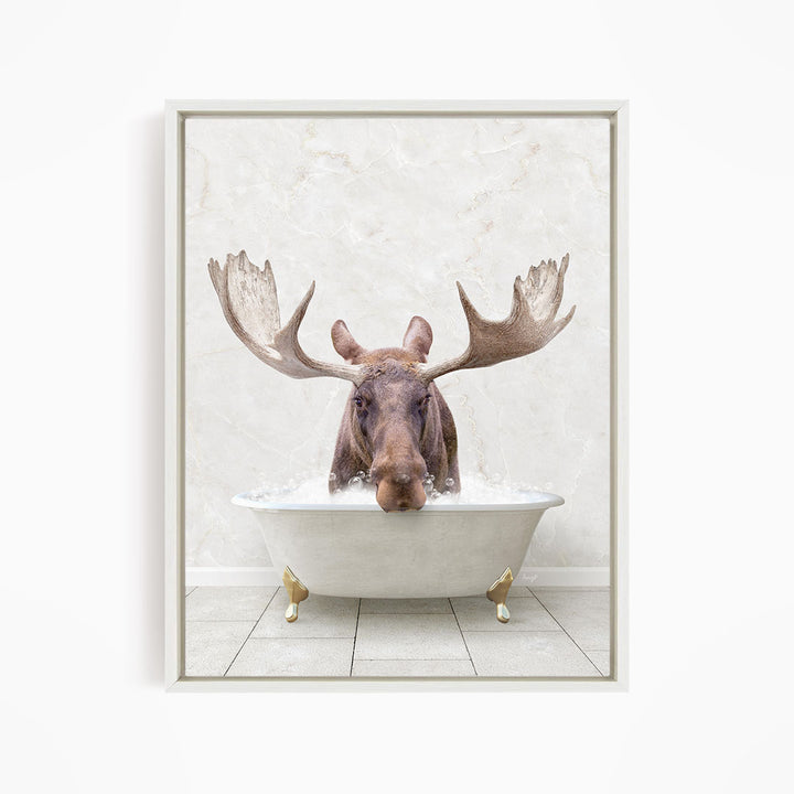 A moose with large antlers is sitting in a white bathtub filled with water, creating a whimsical and humorous scene.