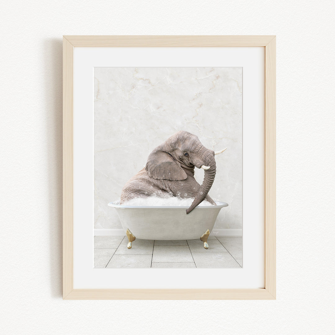 A gray elephant is sitting in a white bathtub, with its trunk raised and appearing to be enjoying the bath.