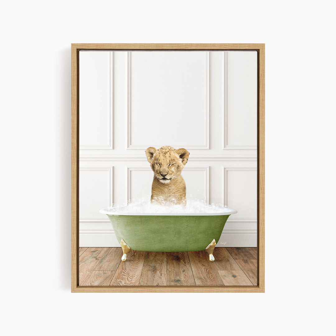 A young lion cub sitting in a green bathtub filled with water, looking directly at the camera.