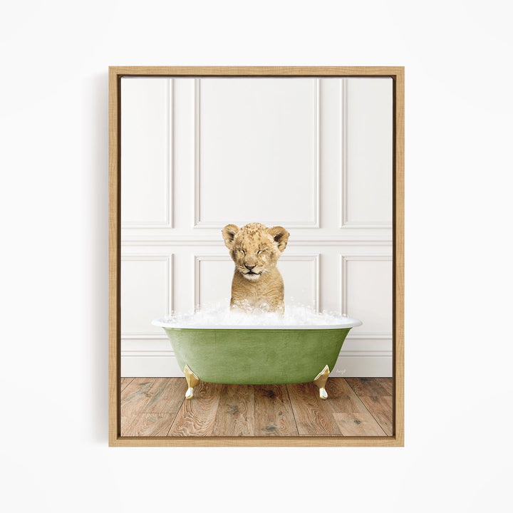 A young lion cub sitting in a green bathtub filled with water, looking directly at the camera.