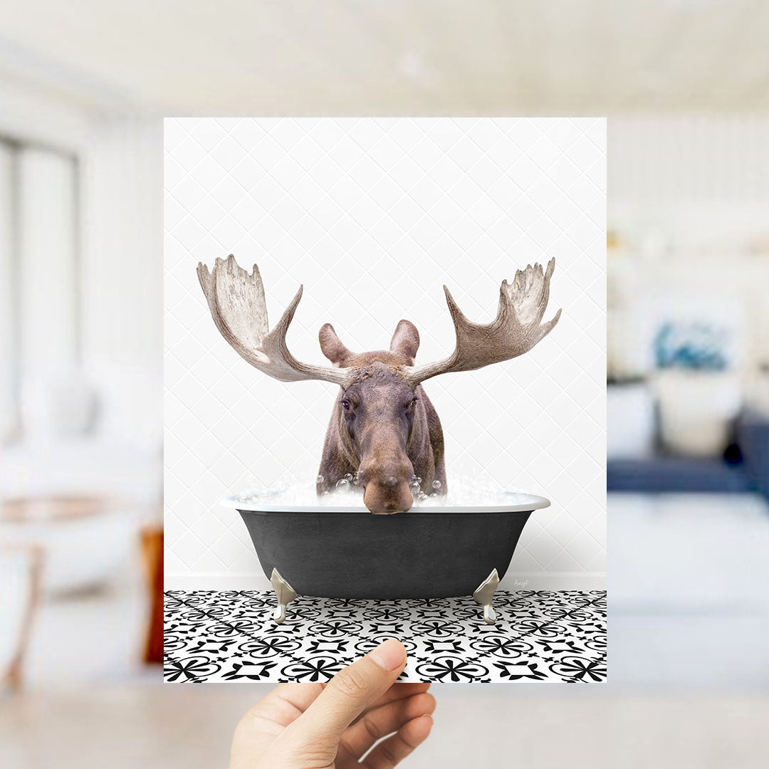 A moose with large antlers is sitting in a bathtub filled with water, creating a whimsical and humorous scene.